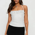 Women's white polka dot top with ruffle detailing, casual wear