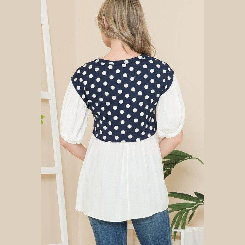 Back view of a women's polka dot tunic top with navy and white design from Orange Farm Clothing