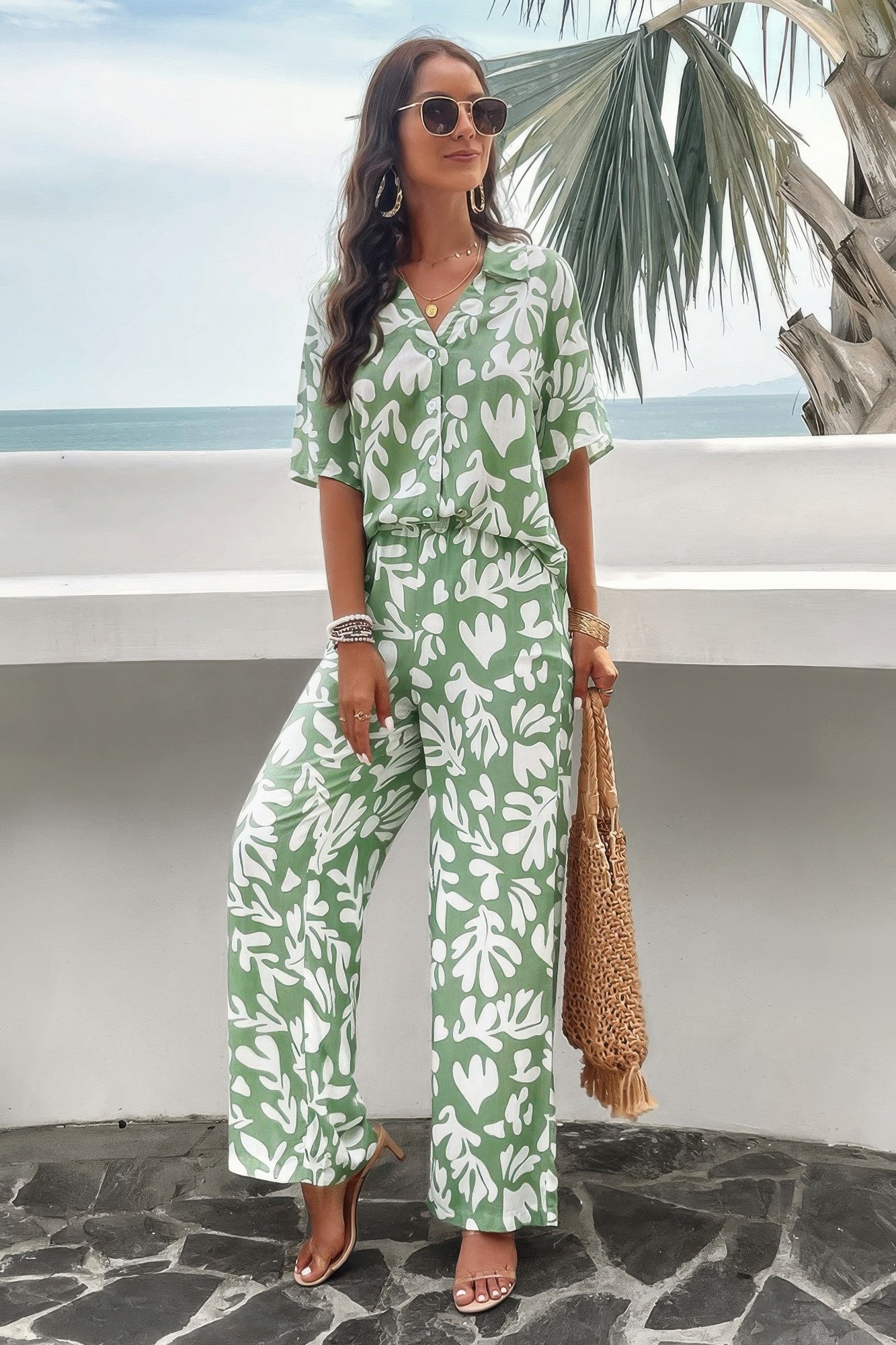 Woman wearing a green and white printed short sleeve pants set with wide-leg pants and sunglasses