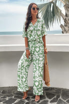 Woman wearing a green and white printed short sleeve pants set with wide-leg pants and sunglasses