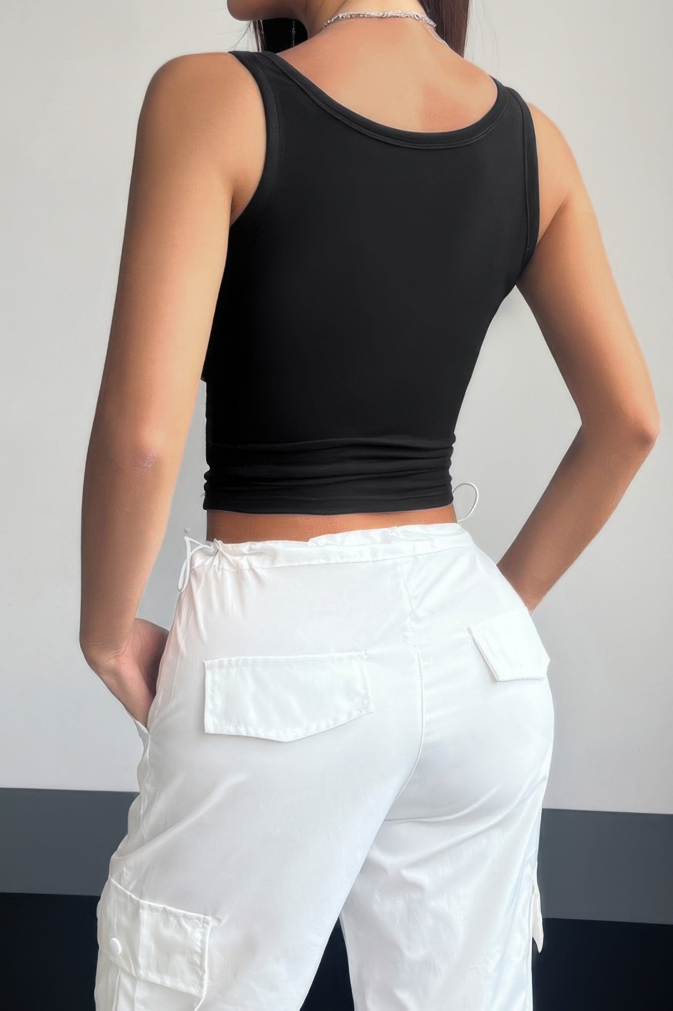 Women wearing black quarter button fit tank for women paired with white cargo pants