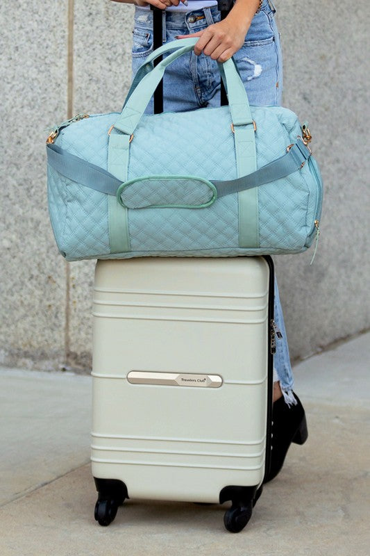 Aili's Corner quilted weekender bag for women in light blue, stylishly placed on top of a suitcase