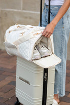 Aili's Corner quilted weekender bag for women being packed over a suitcase with shoes inside