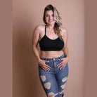 Stylish black racerback bralette plus size paired with distressed high-waisted jeans for a trendy look