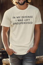 Beige novelty coworker tee with the phrase In My Defense I Was Left Unsupervised displayed prominently