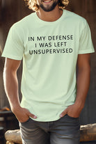 Novelty coworker tee featuring humorous text 'In my defense I was left unsupervised' in light color