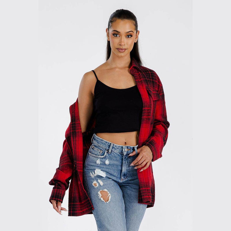 Stylish red black plaid shacket worn over a black crop top with distressed jeans