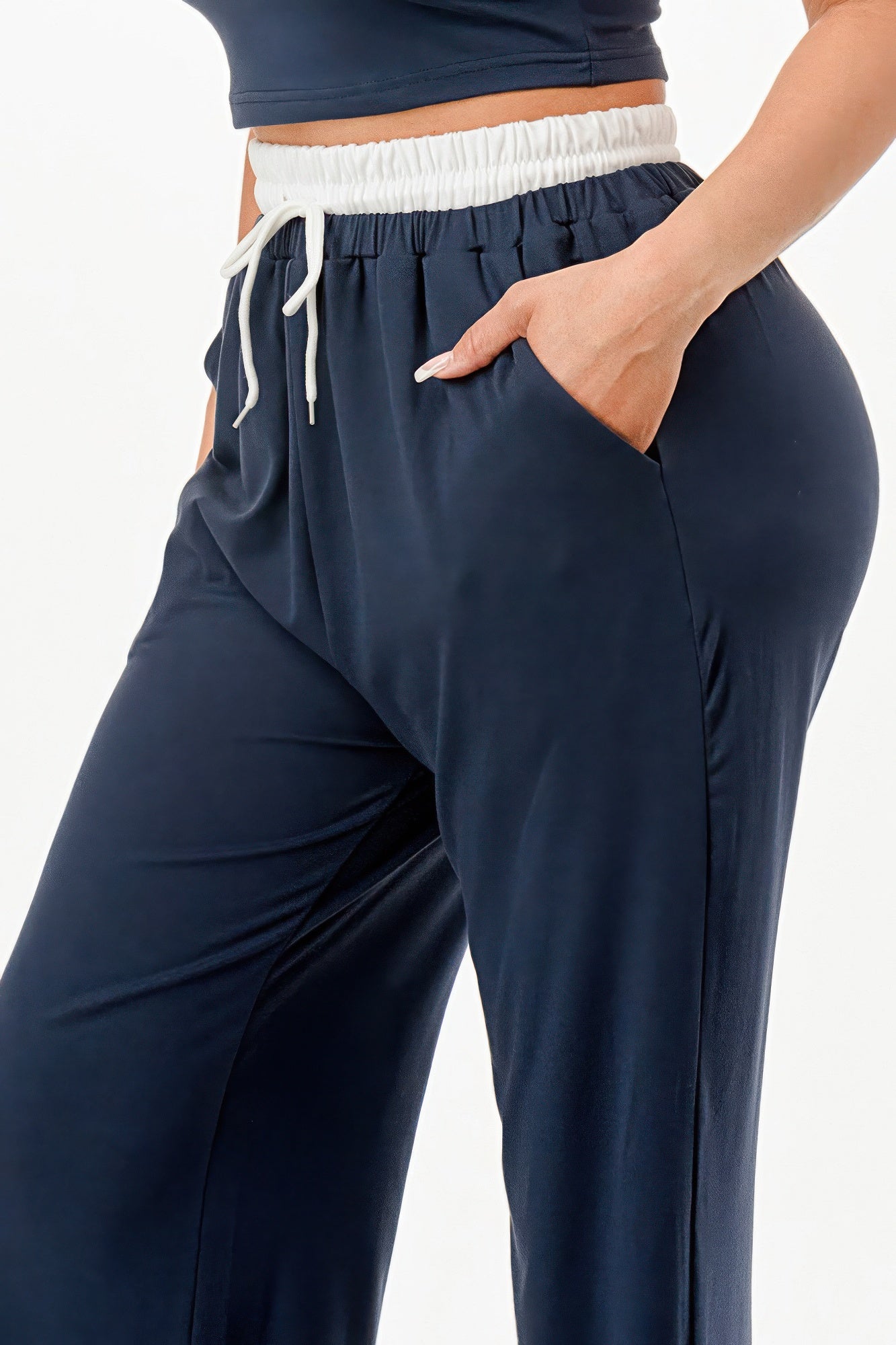 Close-up of navy blue relaxed fit tank and jogger set with white drawstring waistband and side pocket