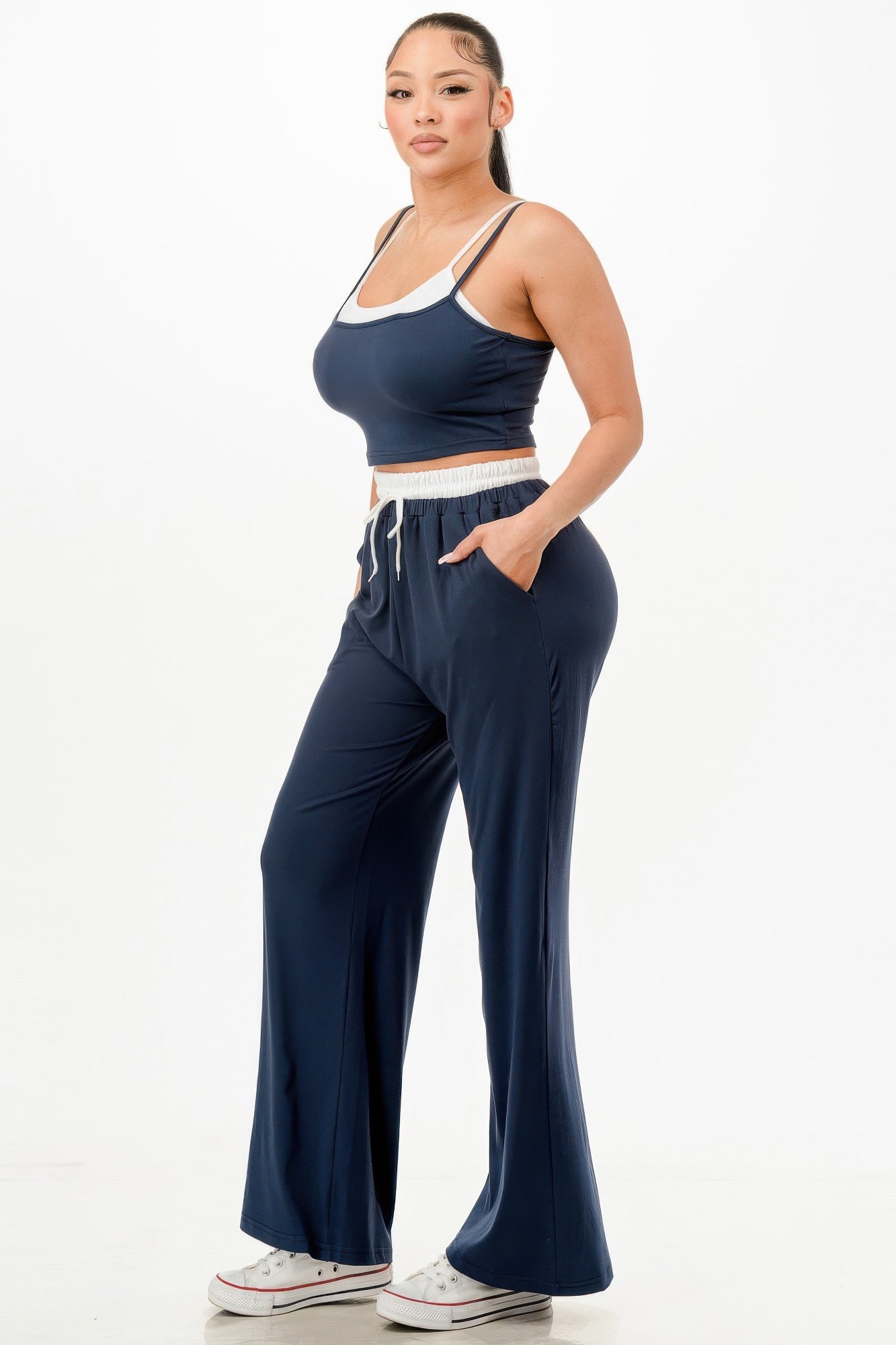Woman wearing navy blue relaxed fit tank and jogger set with white trim and drawstring waist