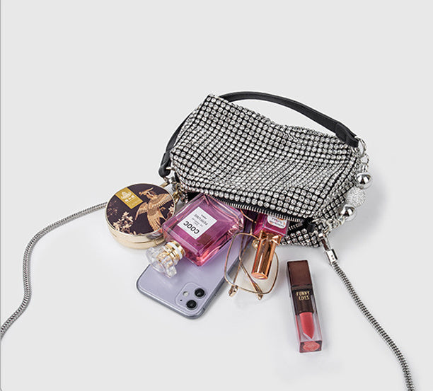 SHOMICOBOUTIQUE rhinestone evening bag with various cosmetics and phone displayed on a light background