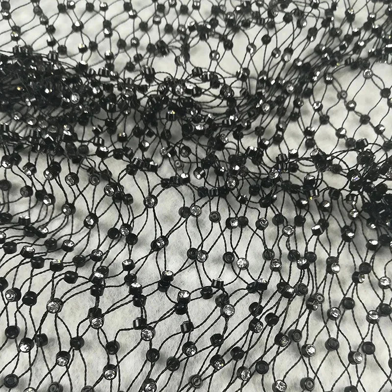 Close-up of black rhinestone fishnet crop top shell only with sparkling details on mesh fabric