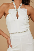Stylish women's rhinestone halter neck jumpsuit with bow detail and shimmering belt.