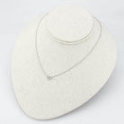 Delicate rhodium crystal heart necklace resting on a display stand for elegant women's jewelry