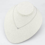 Delicate rhodium crystal heart necklace resting on a display stand for elegant women's jewelry