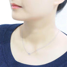 Woman wearing a rhodium crystal heart necklace showcasing its elegant design and sparkle