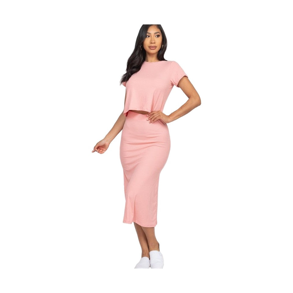 Woman wearing pink ribbed midi skirt set with short sleeves and white slip on shoes