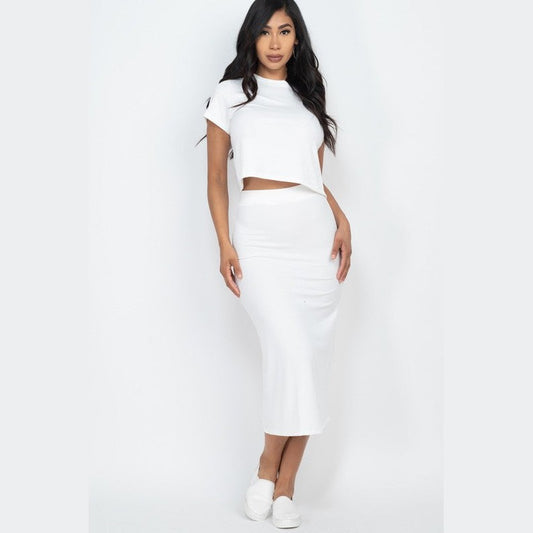 Woman wearing white ribbed midi skirt set with short sleeve crop top and matching fitted skirt