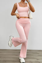 Stylish ruched summer outfit for women in soft pink featuring a fitted crop top and flared pants