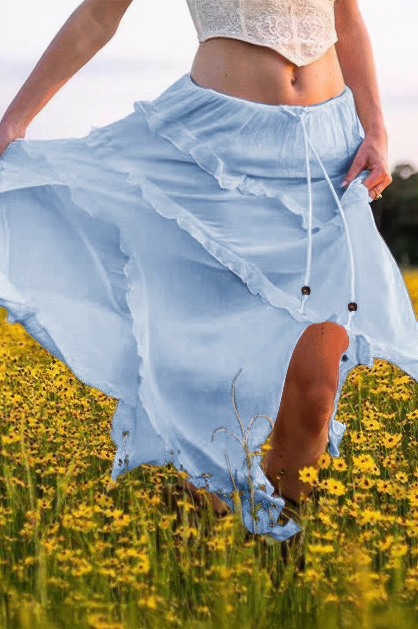 Light blue ruffle drawstring waist skirt flowing in a field of flowers, perfect for summer outfits