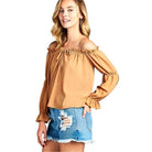 Ivory Felix Ruffled Front Tie Long Sleeve Blouse in tan color, styled with distressed denim shorts