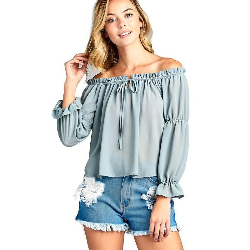 Ivory Felix ruffled front tie long sleeve blouse in light blue paired with distressed denim shorts