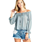Stylish women's ruffled front tie long sleeve blouse in light blue paired with denim shorts