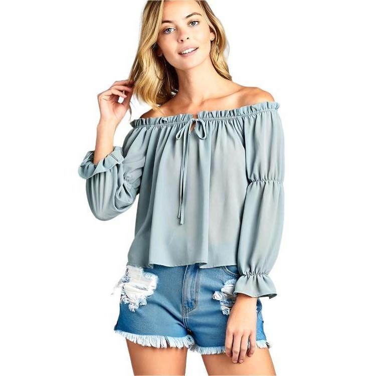 Stylish women's ruffled front tie long sleeve blouse in light blue paired with denim shorts