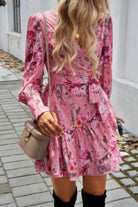 Women's ruffled surplice mini dress in pink floral pattern with long sleeves and waist tie