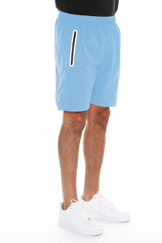 WEIV men's light blue running shorts with zip pocket worn with white sneakers