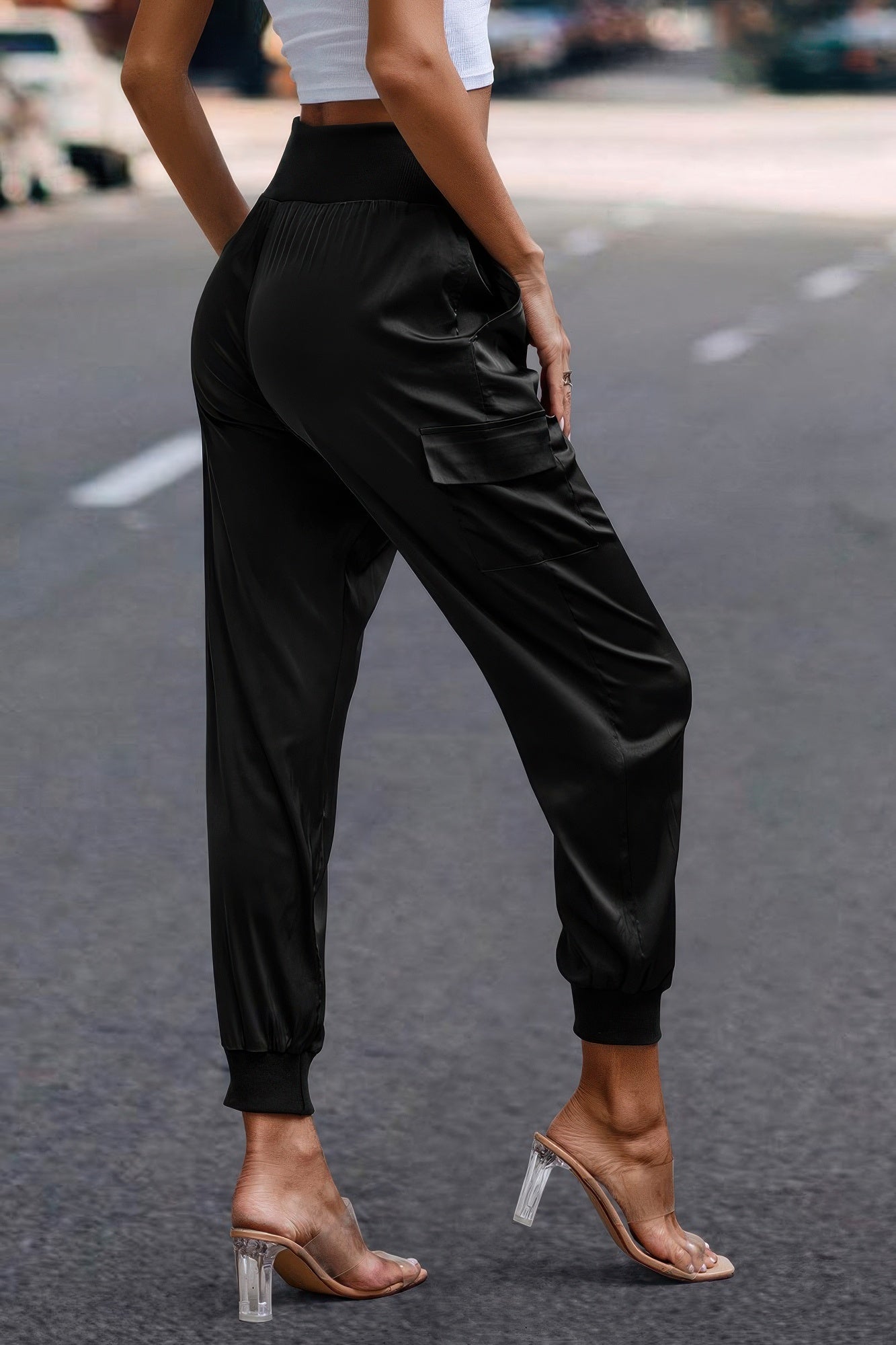 Women's black satin cargo joggers from VacationGrabs with cuffed ankles worn with clear heels