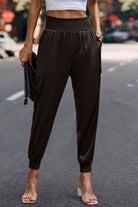 Women wearing black satin cargo joggers with elastic cuffs and high waistband by VacationGrabs