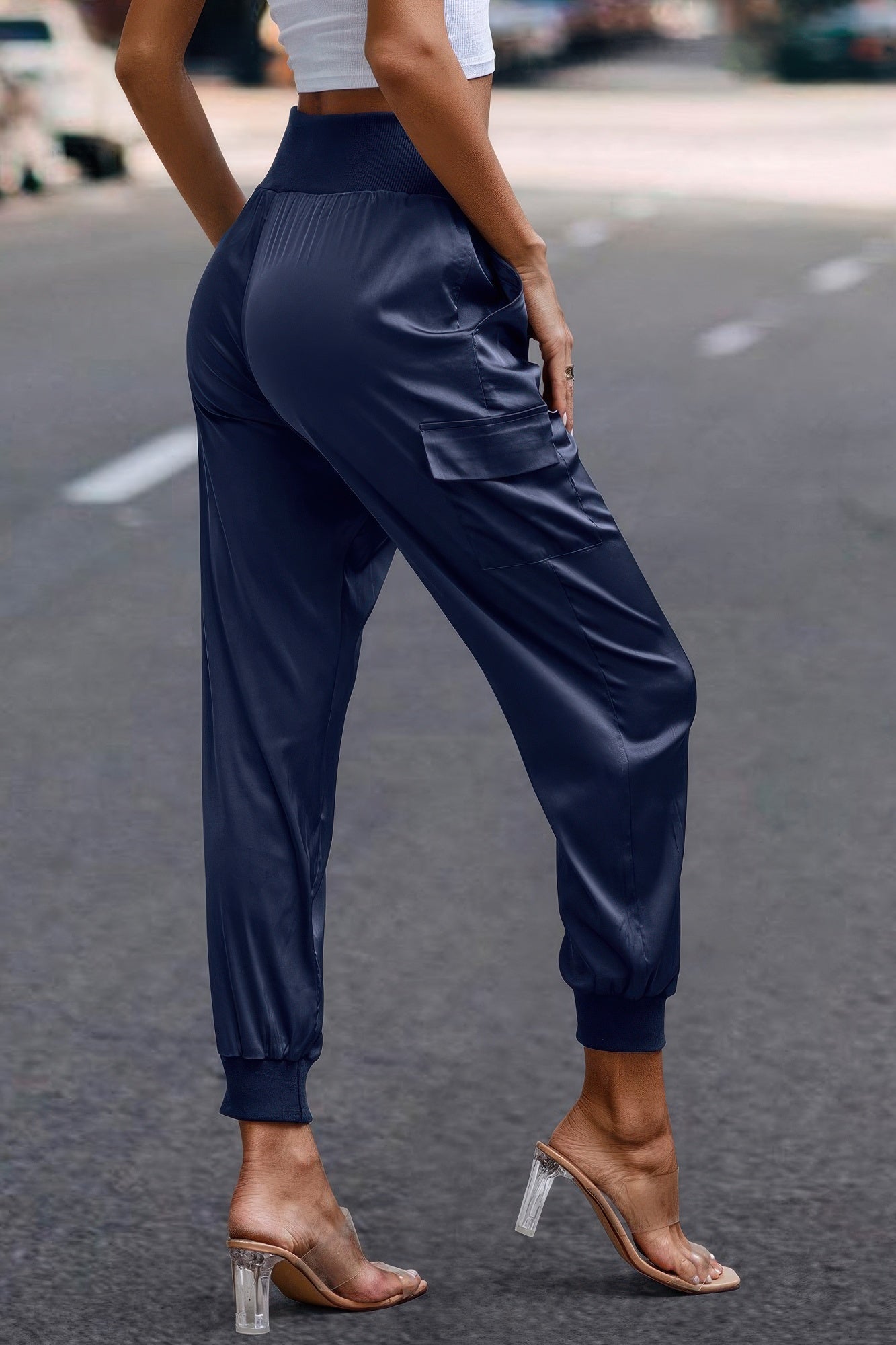 Women wearing navy blue satin cargo joggers with elastic cuffs and high waist on city street