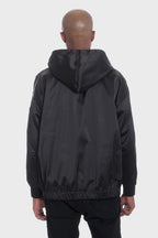 Back view of black satin hooded windbreaker jacket by WEIV worn by male model