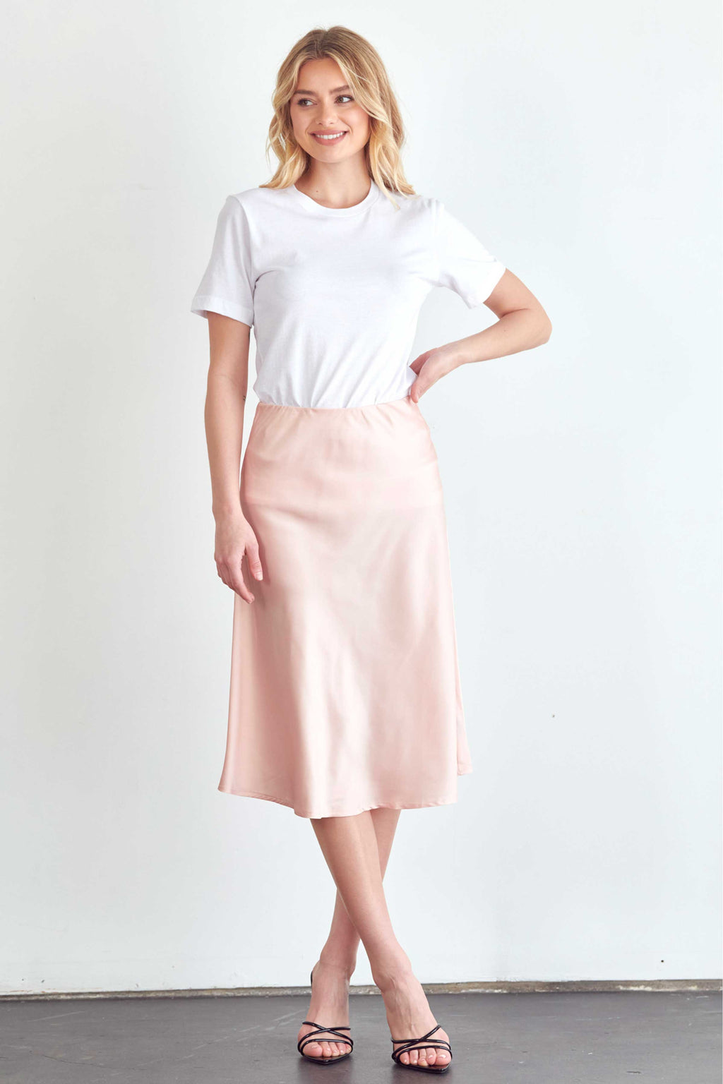BLUME AND CO. satin midi skirt for women in soft pink styled with a white t-shirt and black sandals