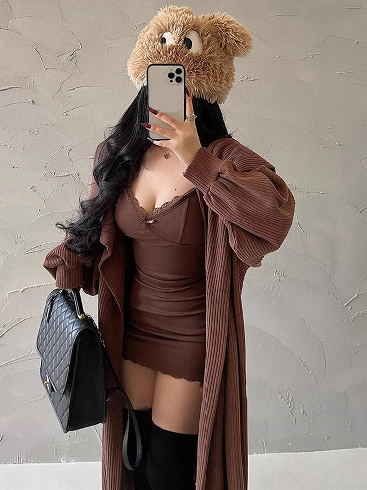 Woman wearing a sexy black club dress for women with a brown oversized cardigan and black handbag