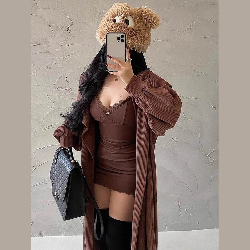 Woman wearing a sexy black club dress for women with a brown oversized cardigan and black handbag