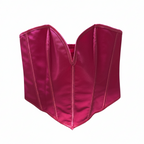 Pink corset on a hanger against a white background