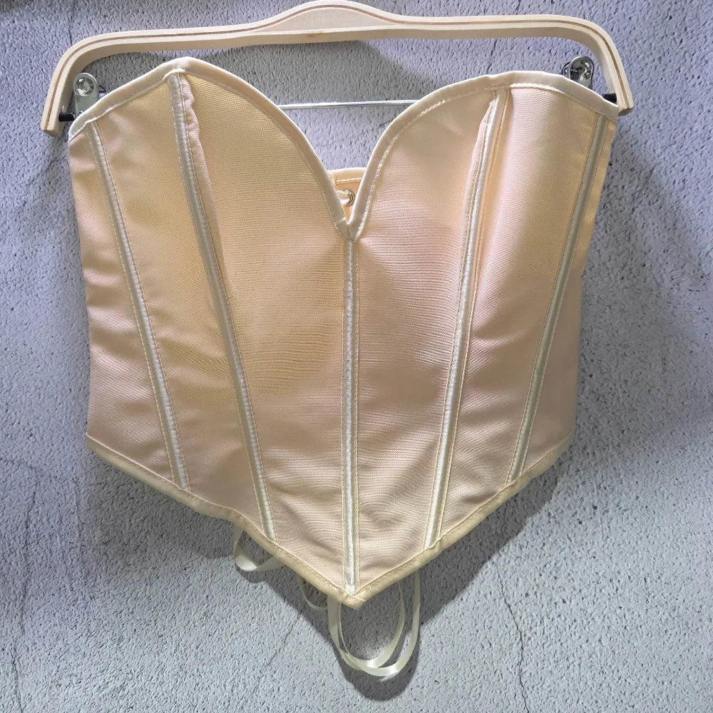 Beige sexy party club bustier top with structured seams hanging on a white hanger