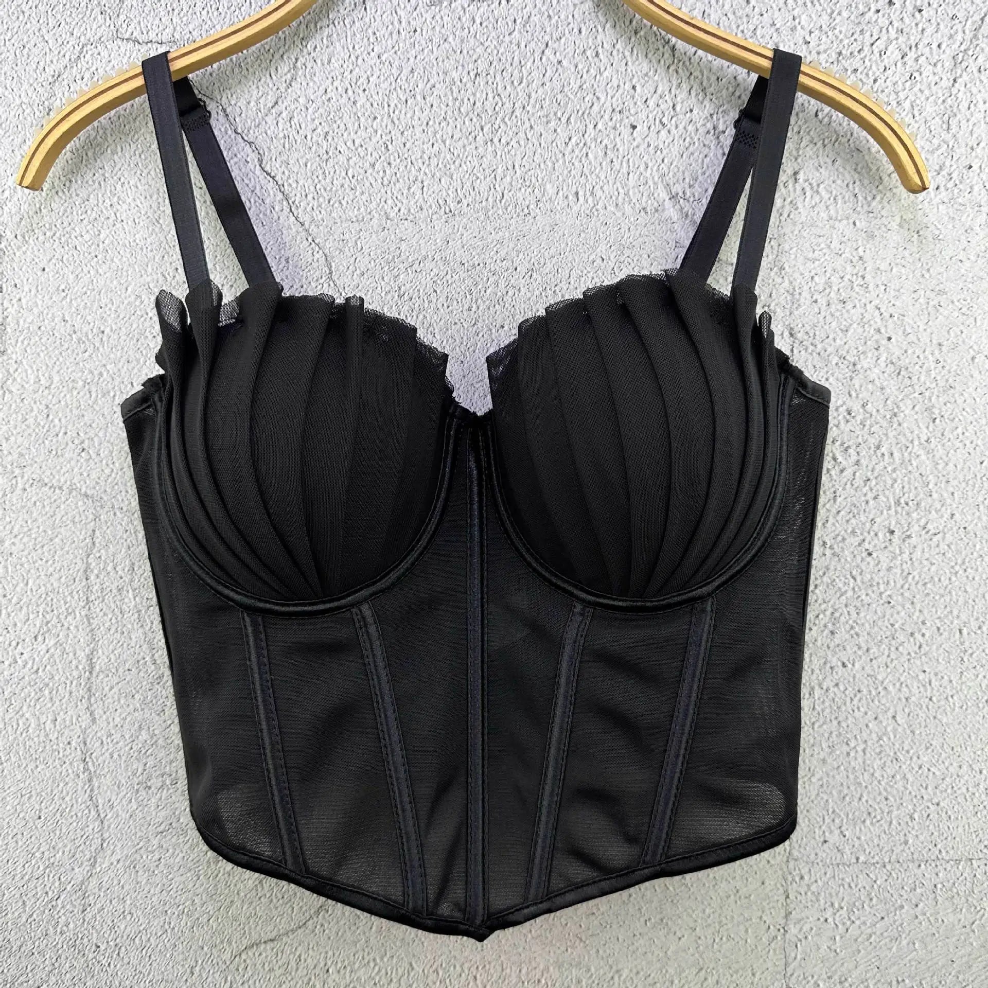 Black sexy party club bustier top with pleated cups and adjustable straps hanging on hanger