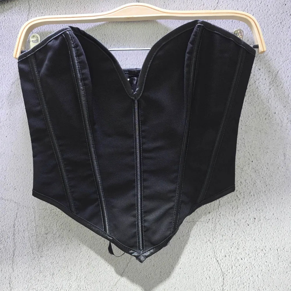 Black sexy party club bustier top with structured seams hanging on wooden hanger