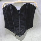 Black sexy party club bustier top with structured seams hanging on wooden hanger