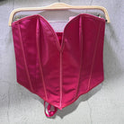 Bright pink sexy party club bustier top with structured seams hanging on wooden hanger