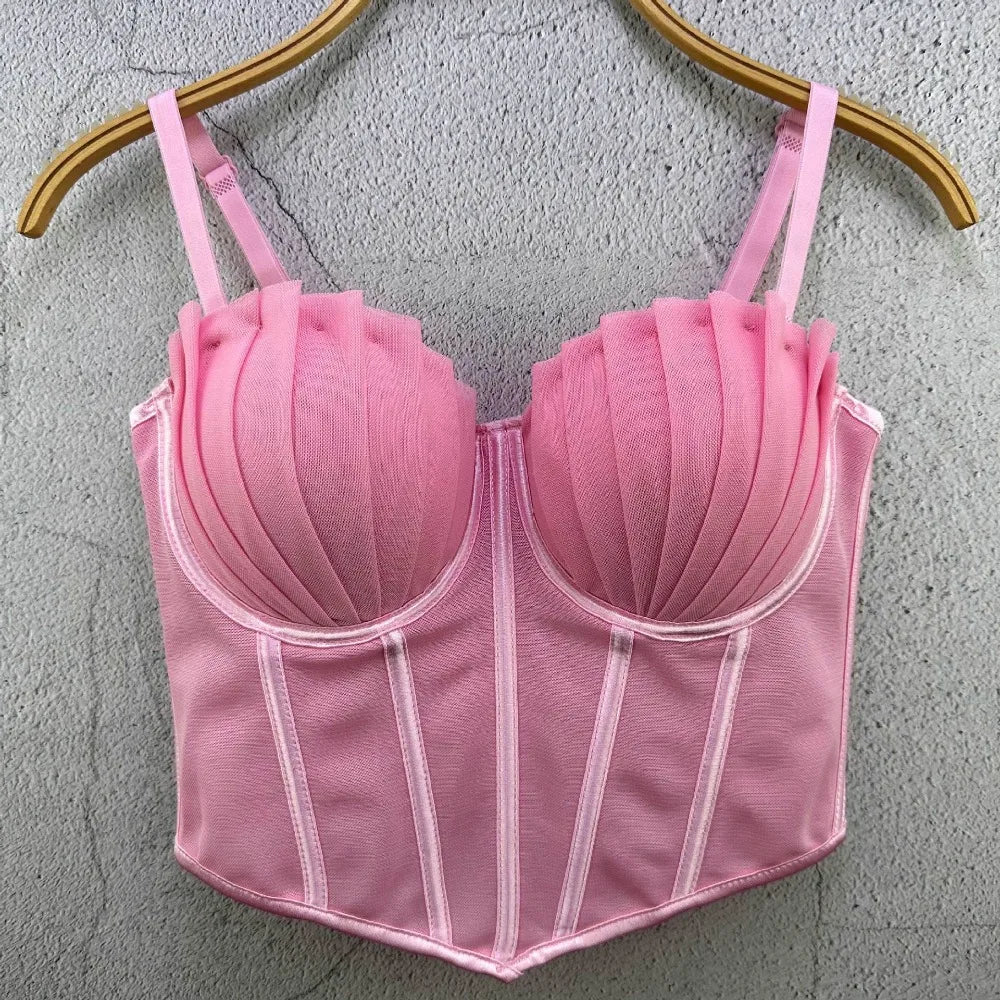 Pink sexy party club bustier top with pleated cups and adjustable straps hanging on wooden hanger