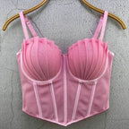 Pink sexy party club bustier top with pleated cups and adjustable straps hanging on wooden hanger
