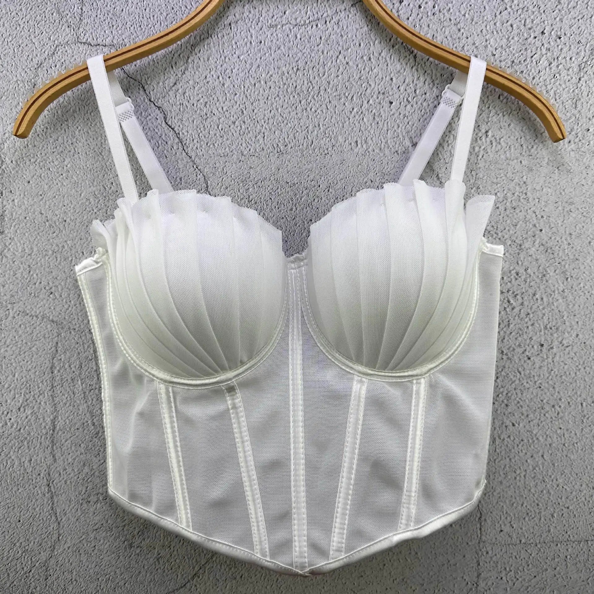 White sexy party club bustier top with structured cups and adjustable straps hanging on wooden hanger