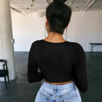 Back view of woman wearing a black sexy summer crop top for women paired with light blue jeans