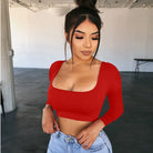 Woman wearing a red sexy summer crop top for women paired with light blue jeans indoors