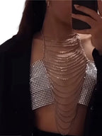 Silver rhinestone body chain top clubwear with cascading chains worn under black outerwear