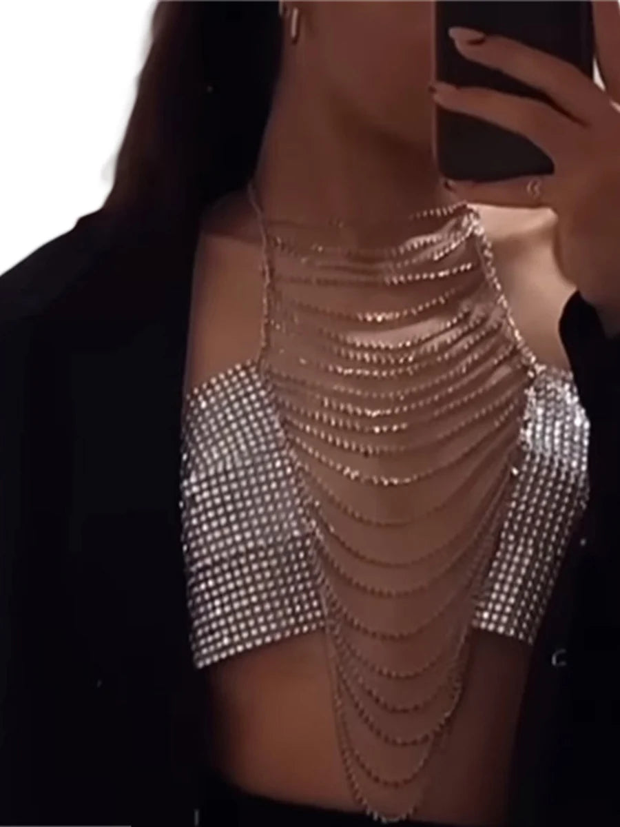 Silver rhinestone body chain top clubwear with cascading chains worn under black outerwear