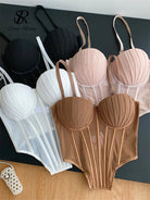 Set of sexy bustier camisole for ladies in black white beige and brown colors laid out on black surface